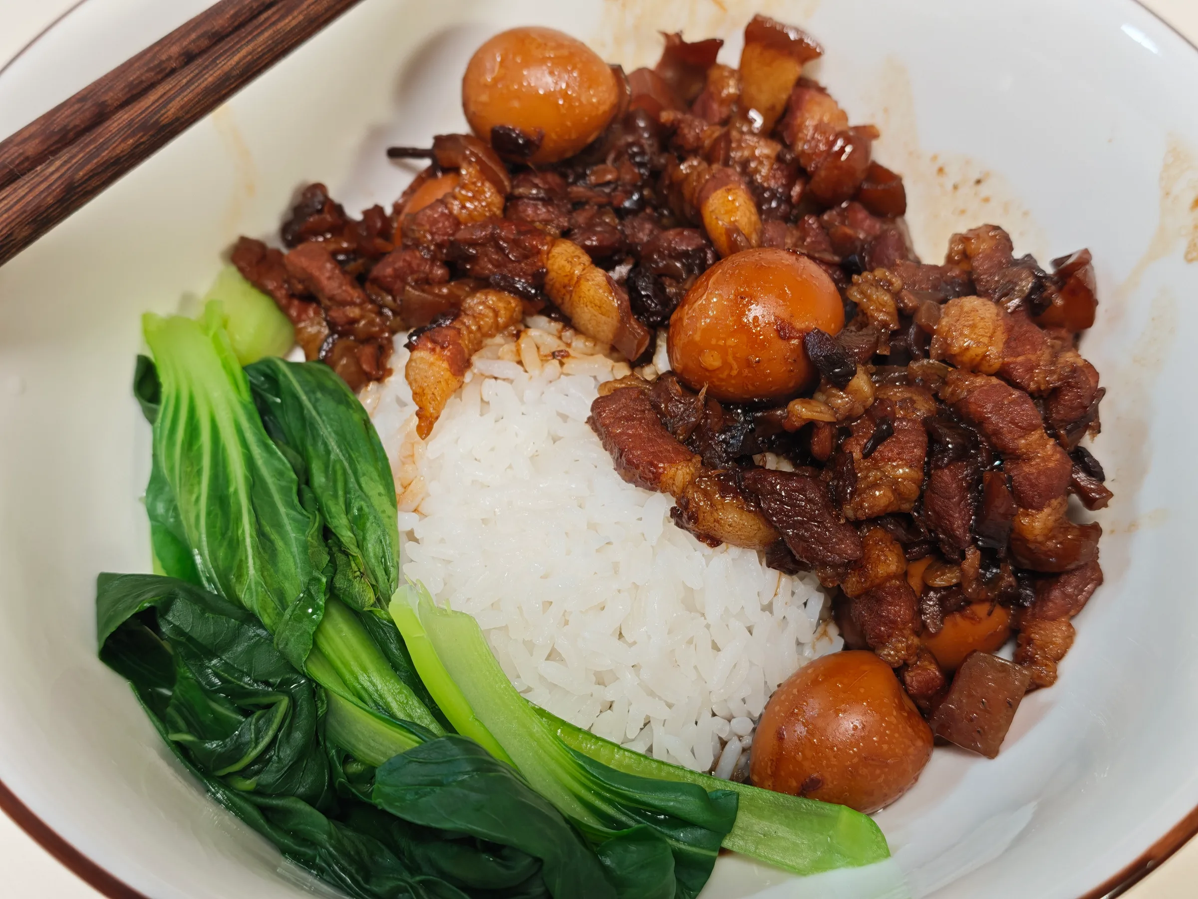 Braised pork over rice with quail eggs and blanched greens