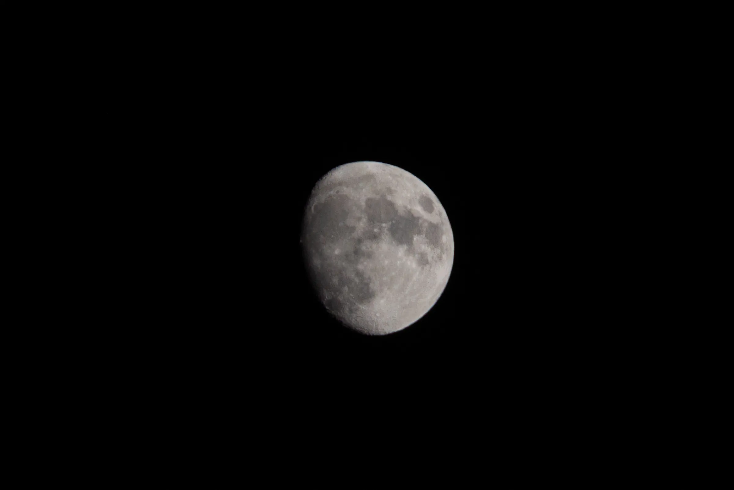 A waxing gibbous moon in a black sky