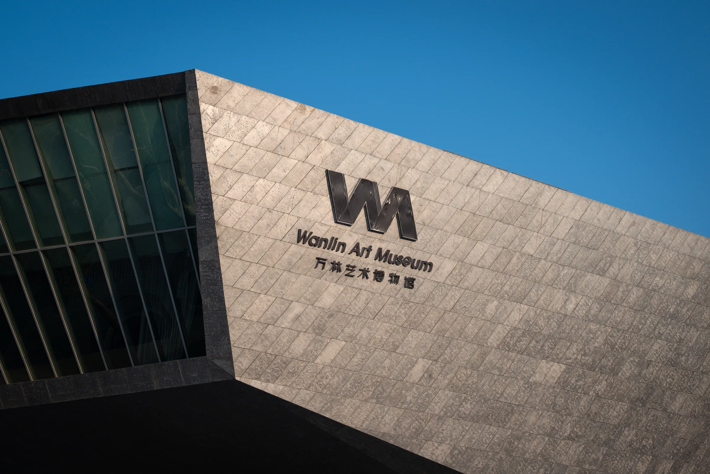 The stone facade of the Wanlin Art Museum against the sky